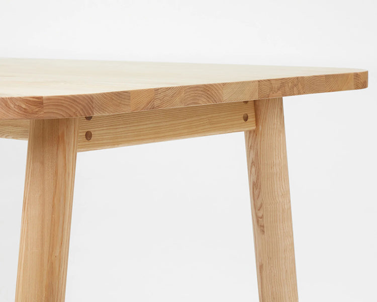 LAX Milk Dining Table by MASHstudios, showing closeup view of lax milk dining table in solid ash wood.