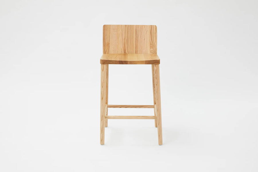 LAX Milk Stool by MASHstudios, showing front view of lax milk stool in counter/solid ash wood.