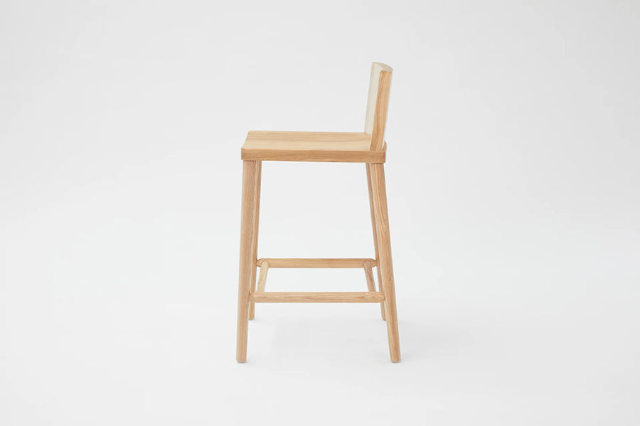 LAX Milk Stool by MASHstudios, showing side view of lax milk stool in counter/solid ash wood.