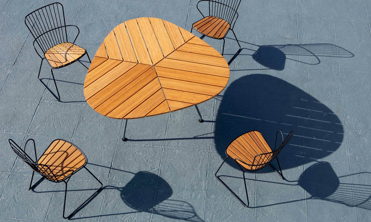 Leaf Outdoor Dining Table by Houe, showing leaf outdoor dining table with chairs in live shot.