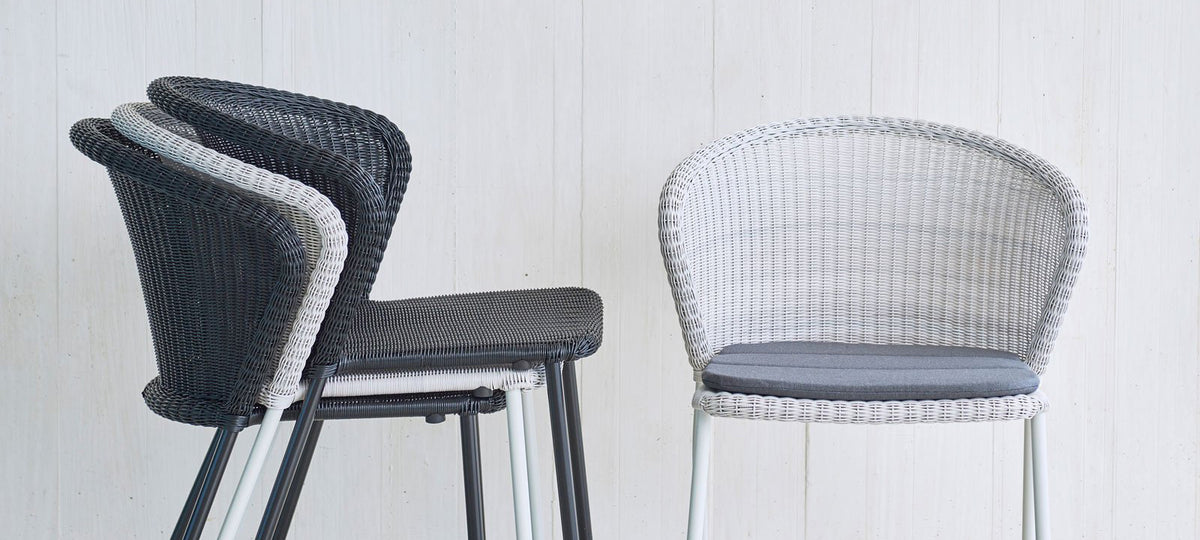 Lean Stackable Dining Chair by Cane-Line, showing lean stackable dining chairs in live shot.