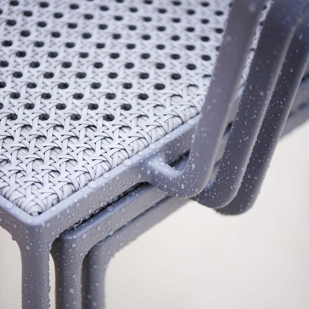 Less Stackable Dining Armchair by Cane-Line, showing closeup view of less stackable dining armchairs in live shot.