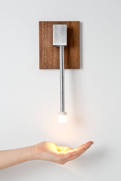 Libri LED Reading Sconce by Cerno, showing libri led reading sconce with walnut backplate in live shot.