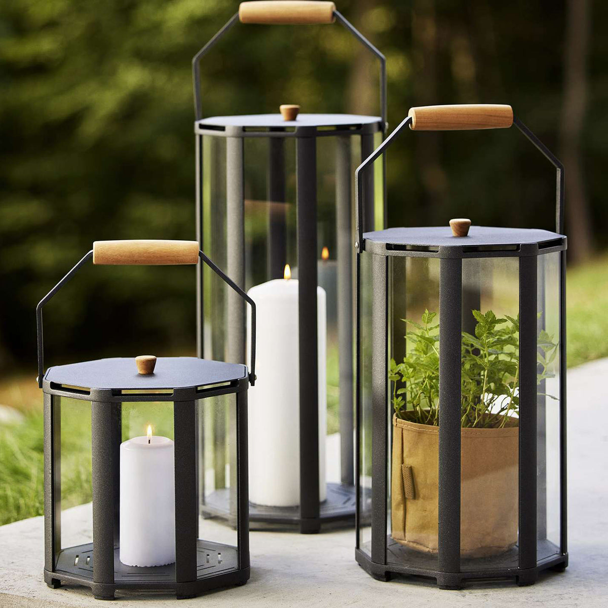 Lightlux Lantern with Teak Handle by Cane-Line, showing lightlux langerns with teak handle in live shot.