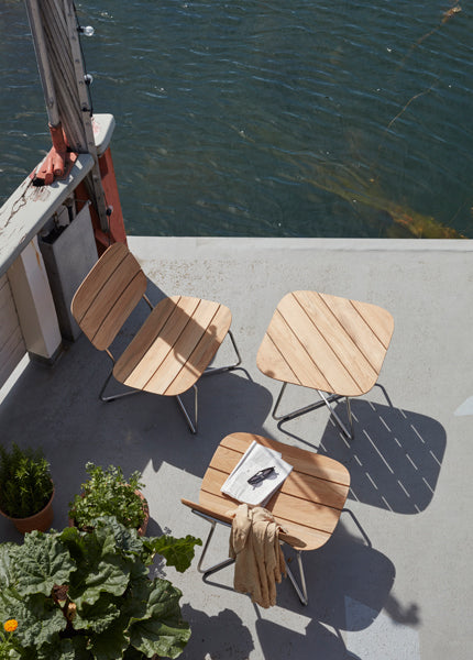 Lilium Teak Lounge Table by Skagerak, showing lilium teak lounge table with lounge chairs in live shot.