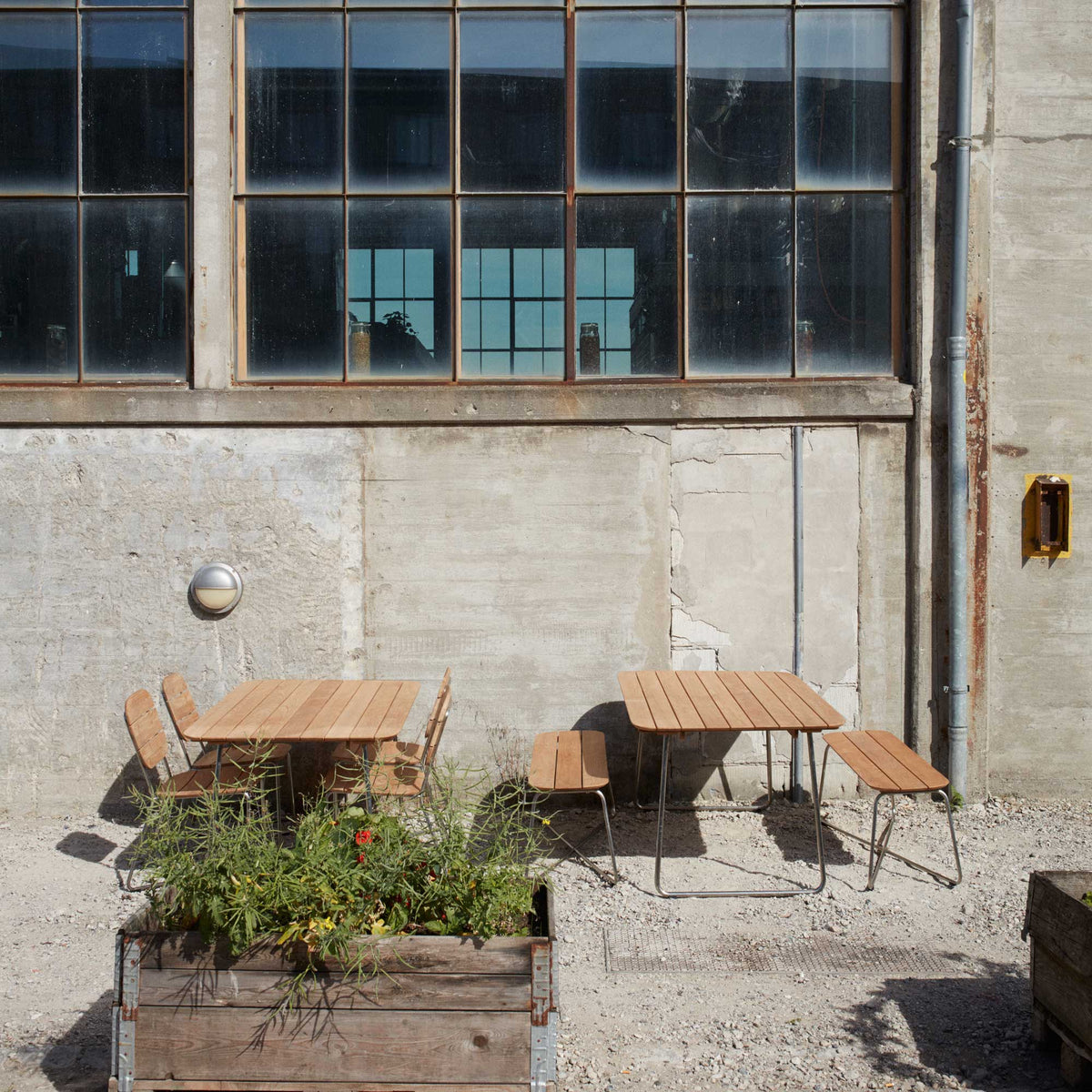 Lilium Teak Table by Skagerak, showing lilium teak tables with benches in live shot.