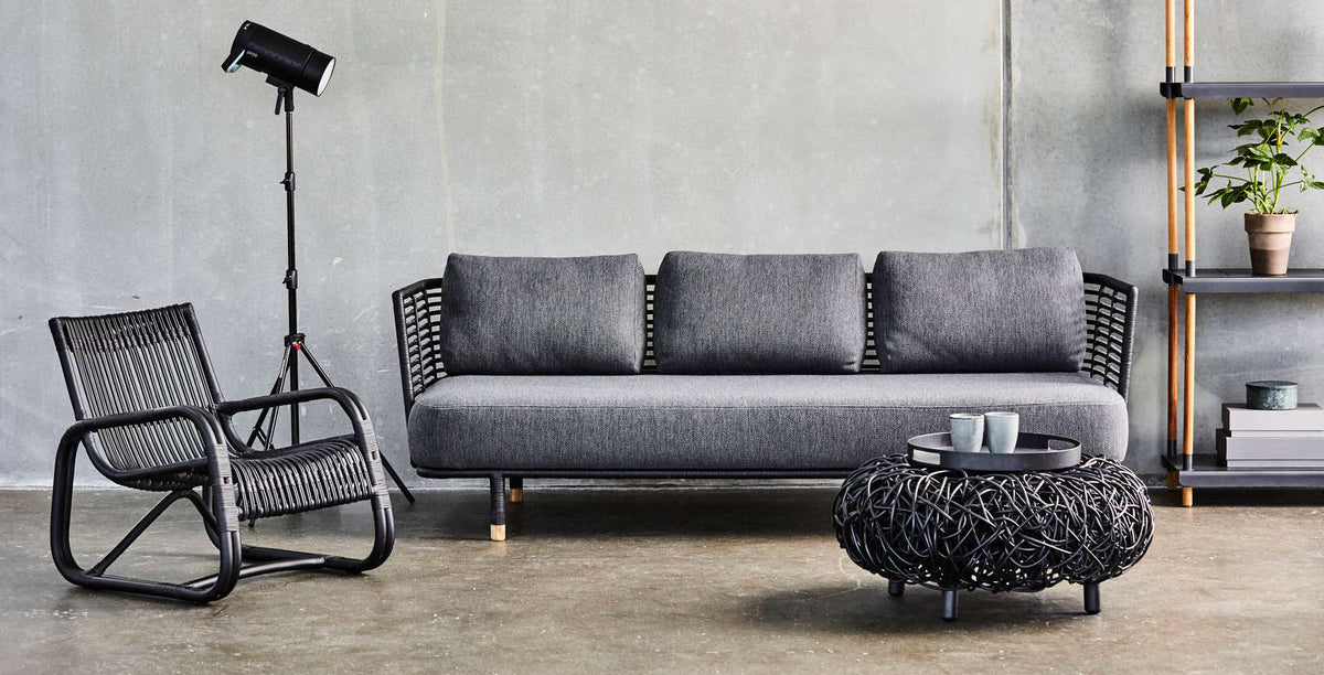 Loop Footstool by Cane-Line, showing loop footstool with sofa & chair in live shot.