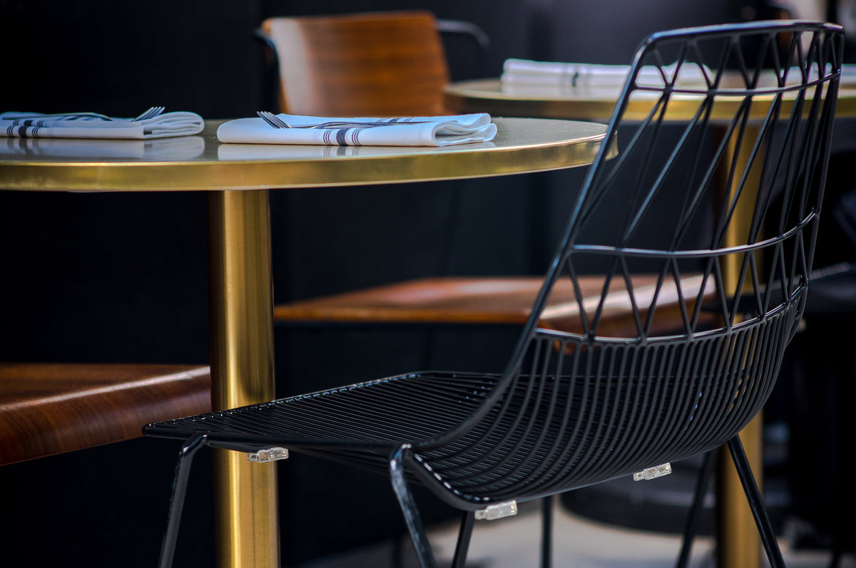 Lucy Stacking Chair by Bend, showing lucy stacking chair with table in live shot.