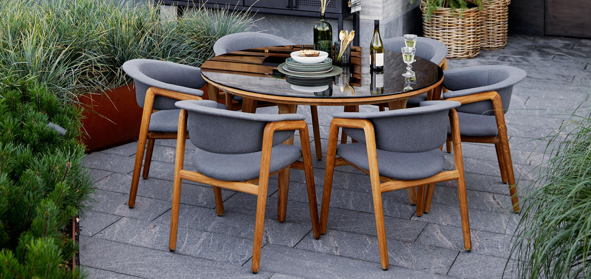 Luna Dining Chair by Cane-Line, showing luna dining chairs with table in live shot.