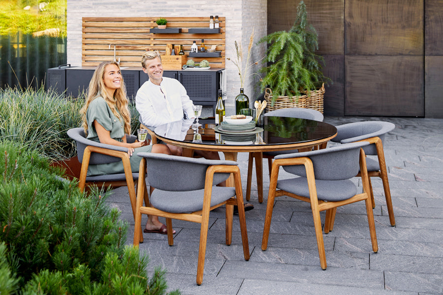 Luna Dining Chair by Cane-Line, showing luna dining chairs with table in live shot.