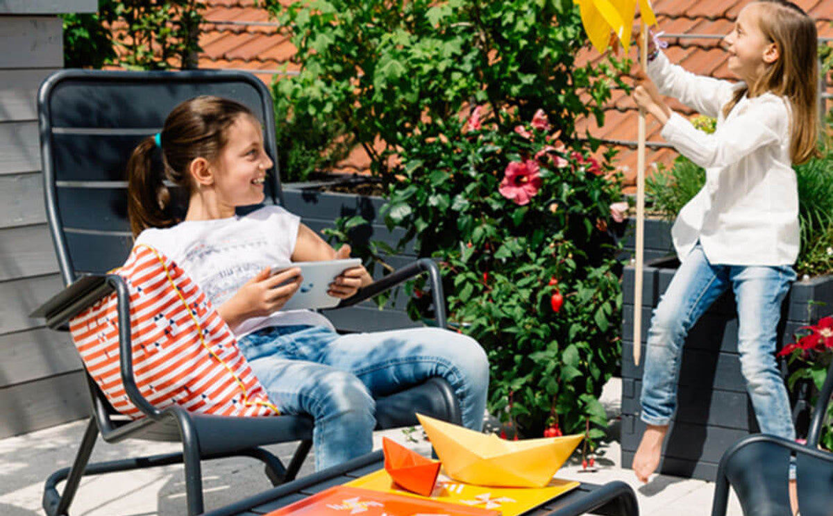 Luxembourg Rocking Chair by Fermob, showing rocking chair with large low table in live shot