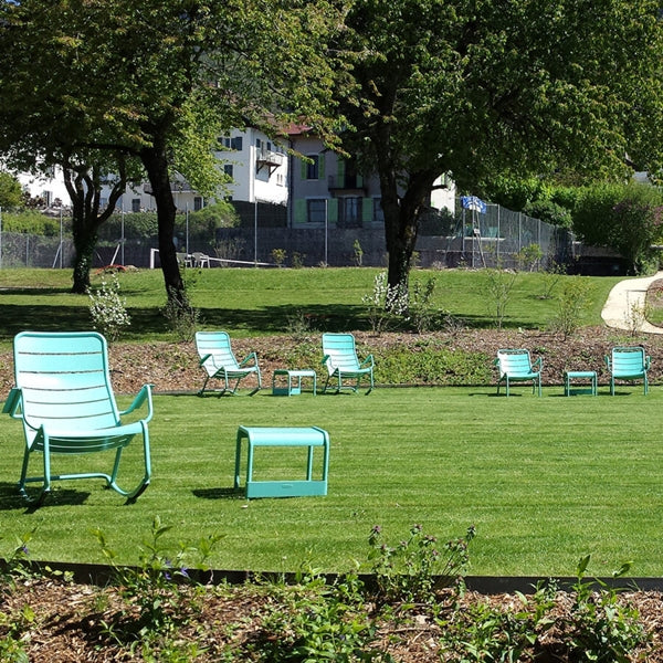 Luxembourg Small Low Table / Footrest by Fermob, showing small low table/footrests with lounge chairs in live shot.