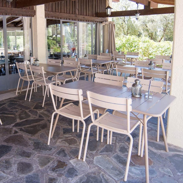 Luxembourg Rectangular Table by Fermob, showing rectanle tables 56" x 32" with chairs in live shot.