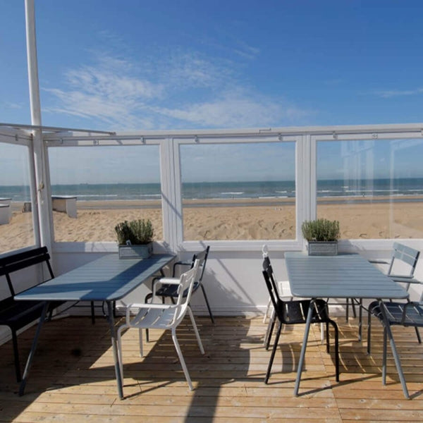 Luxembourg Rectangular Table by Fermob, showing rectanle tables 56" x 32" with chairs in live shot.
