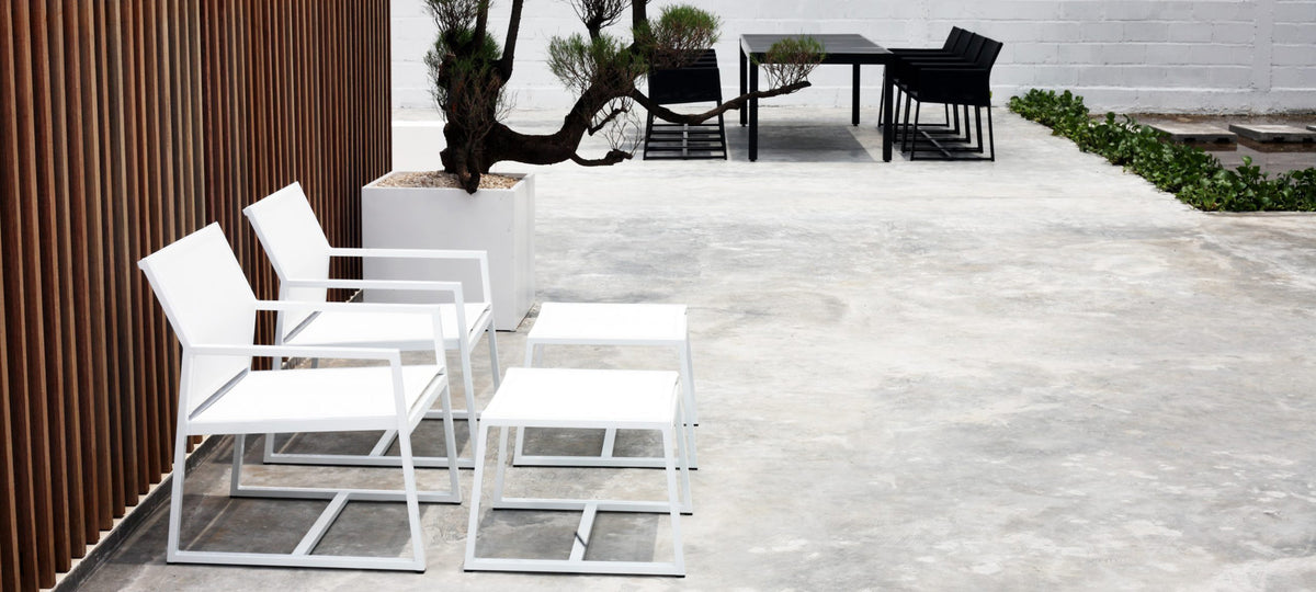 Allux Footrest by Mamagreen, showing two footrests with two casual armchirs in live shot.