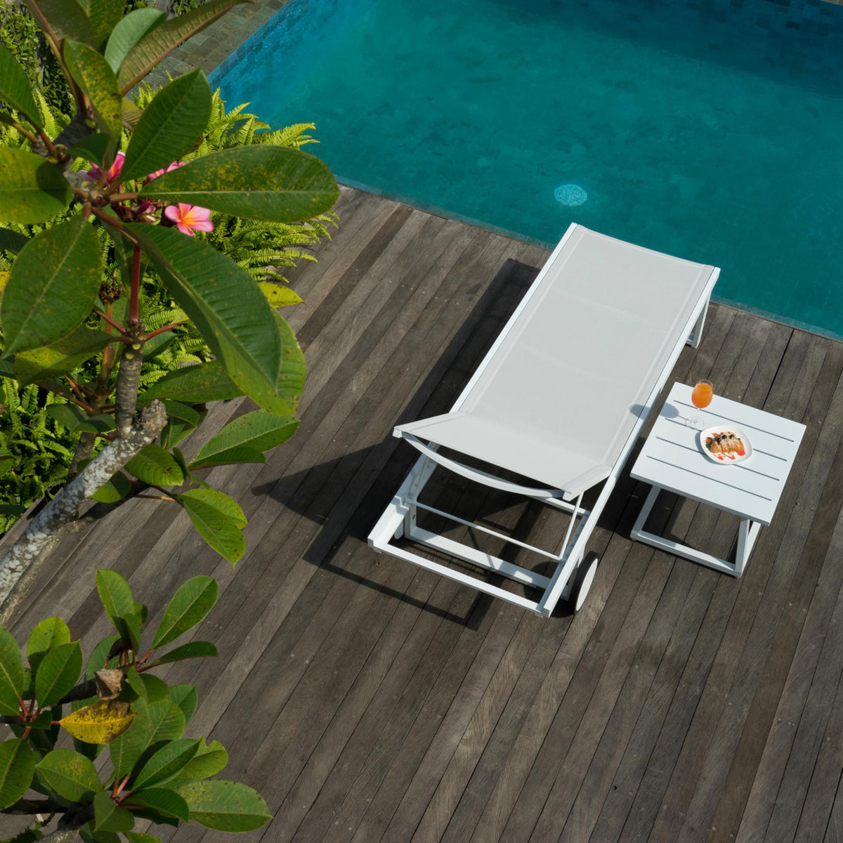 Allux Aluminum Wheels Lounger by Mamagreen, showing top view of lounger and side table in live shot.