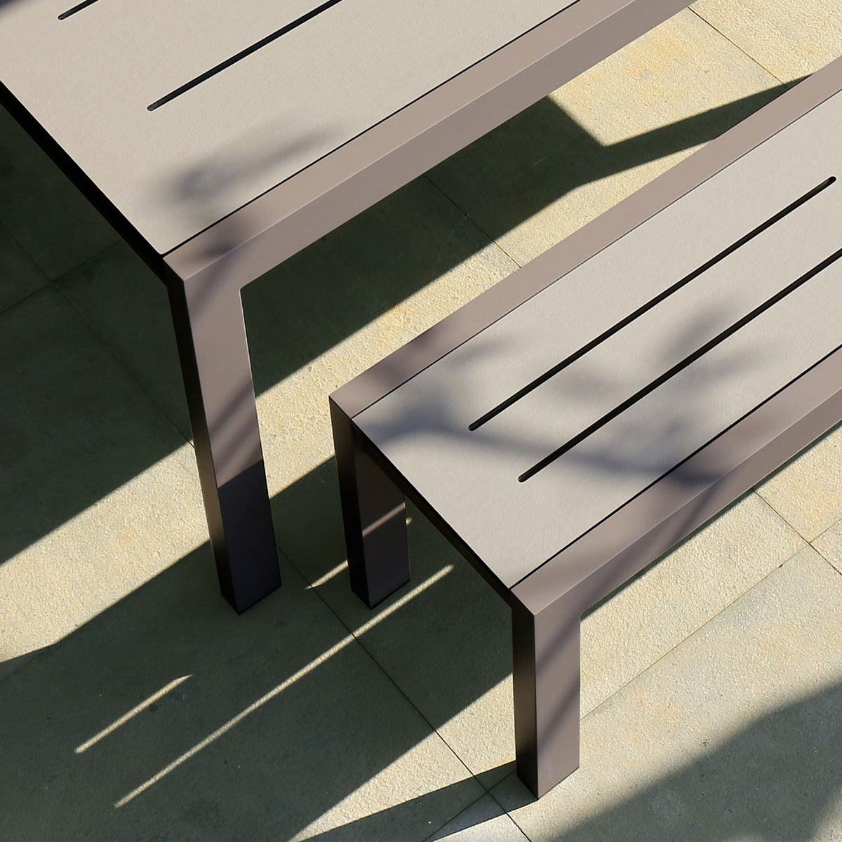 Baia HPL Aluminum 57" Bench by Mamagreen, showing closeup view of baia hpl aluminum 57" bench with hpl aluminum extendable 67" dining table in live shot.