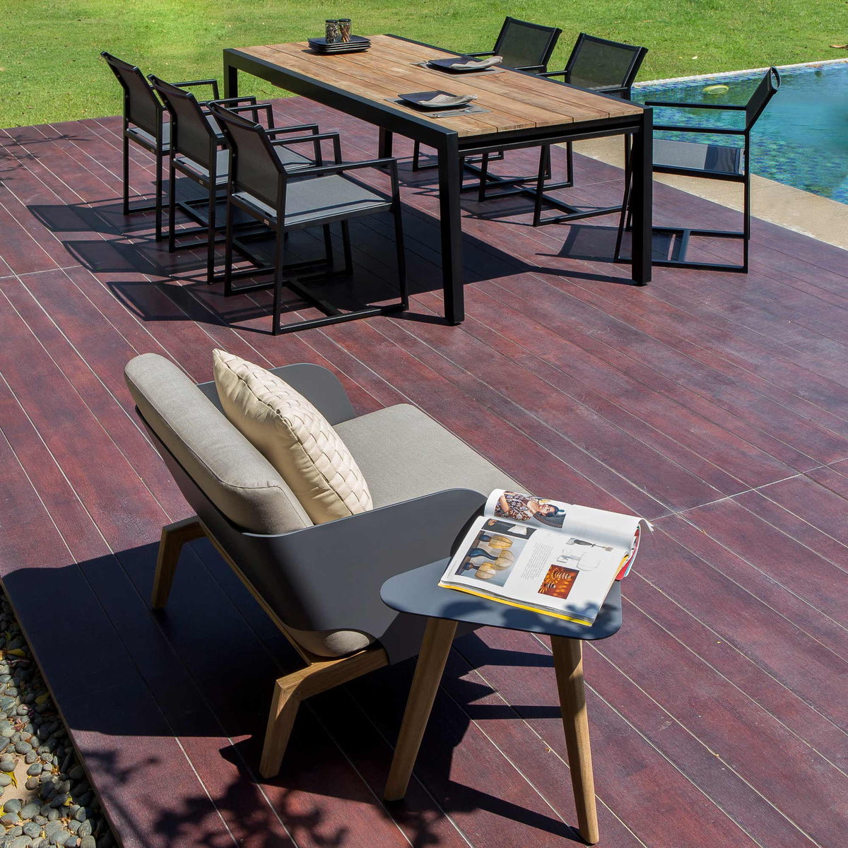 Baia Teak Aluminum Extendable Dining Table by Mamagreen, showing baia teak aluminum extendable dining table, allux carver chair, kaat 1 seater and kaat side table in live shot.