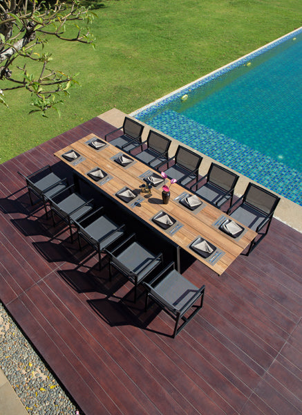 Baia Teak Aluminum Extendable Dining Table by Mamagreen, showing baia teak aluminum extendable dining table with allux carver chair in live shot.