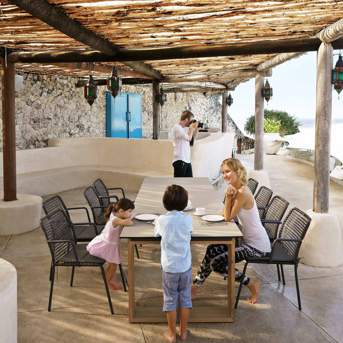 Manda Aluminum Stackable Woven Dining Chair by Mamagreen, showing group of manda aluminum stackable woven dining chair with aiko dining table in live shot.