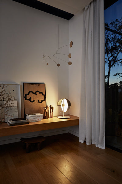 Theia Table Lamp by Marset, showing angle view of white table lamp in live shoot.