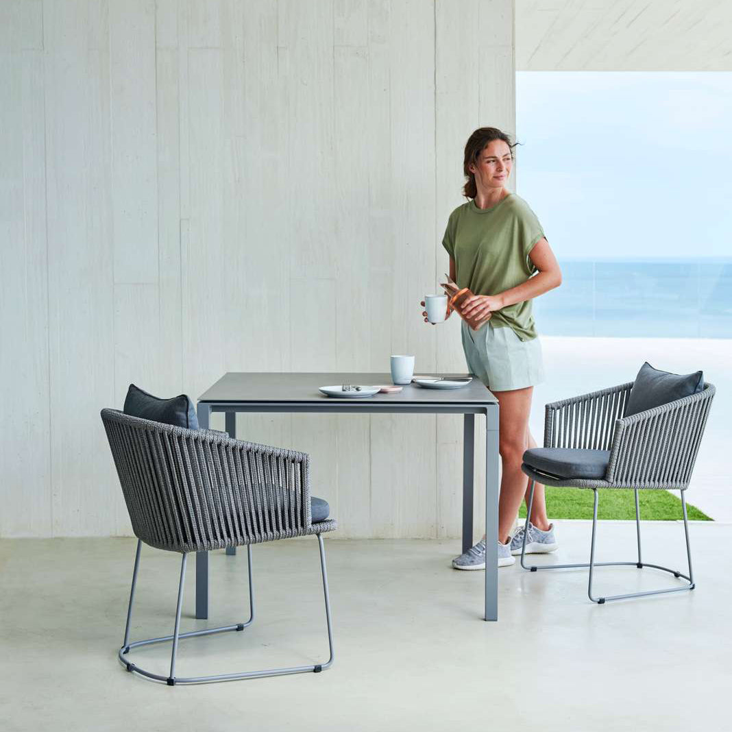 Moments Dining Armchair by Cane-Line, showing moments dining armchairs with table in live shot.