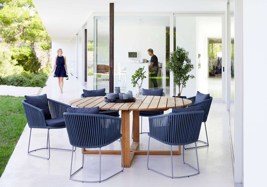 Moments Dining Armchair by Cane-Line, showing moments dining armchairs with table in live shot.