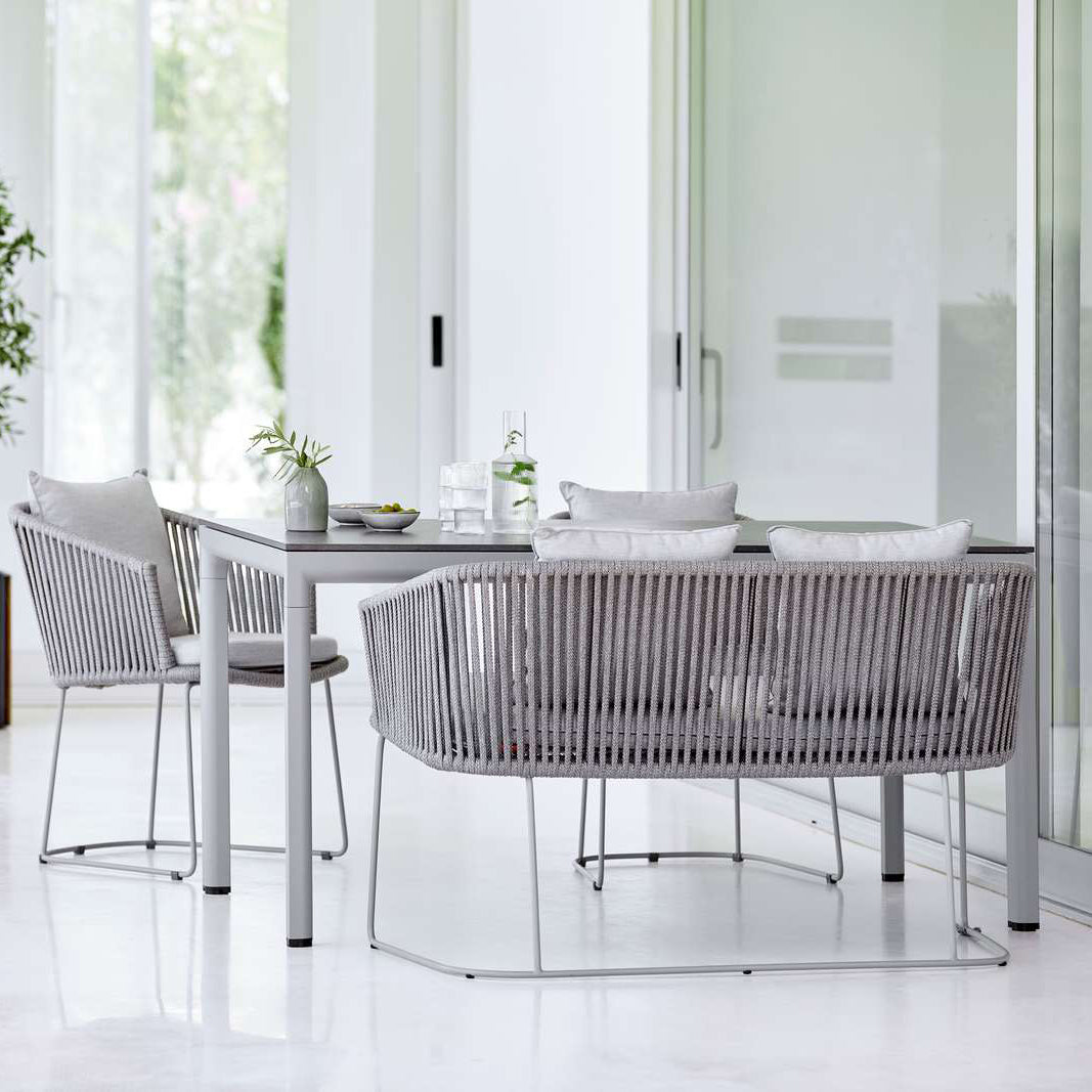 Moments Outdoor Dining Bench by Cane-Line, showing moments outdoor dining bench with chairs & table in live shot.