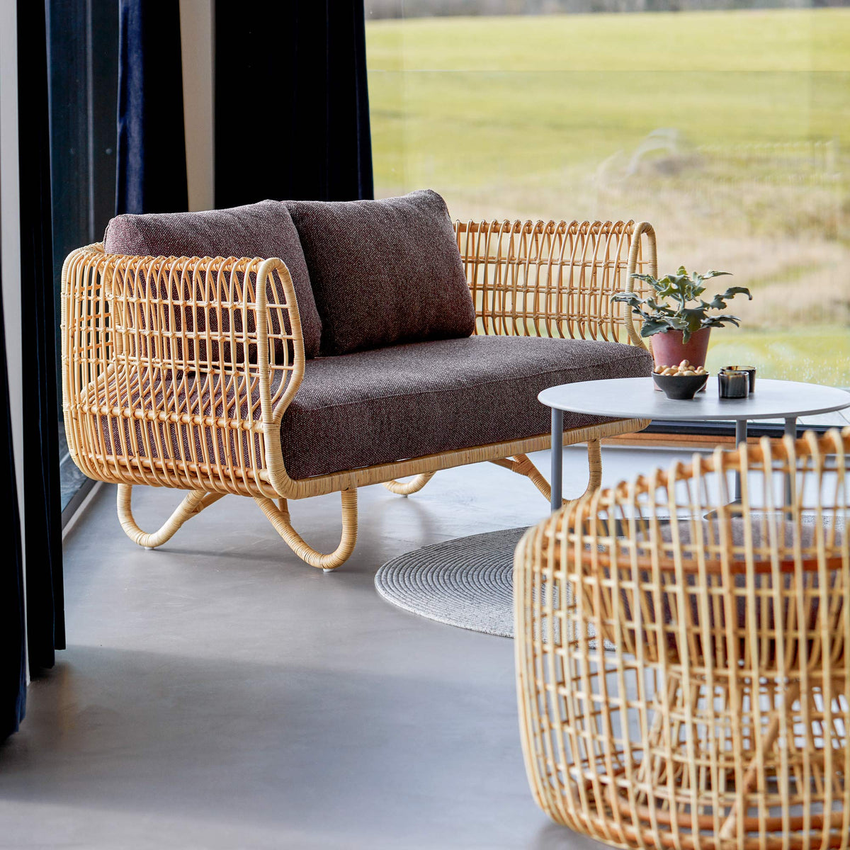 Nest Indoor Sofa by Cane-Line, showing nest indoor sofa with chairs & table in live shot.