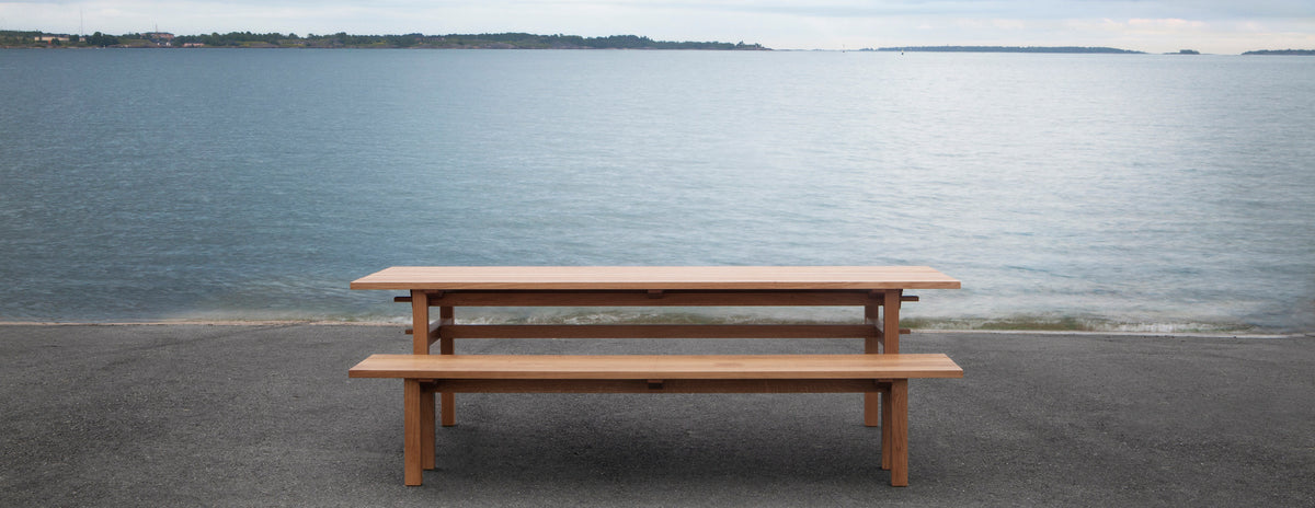 Arkipelago KVP10 Table by Nikari, showing arkipelago kvp10 table with bench in live shot.