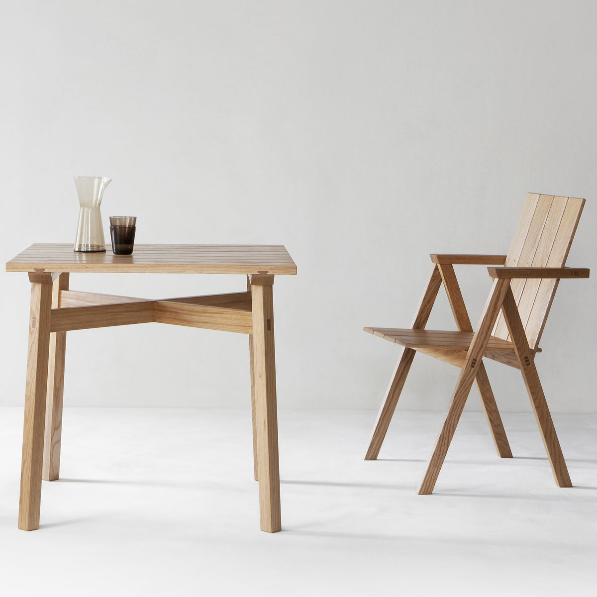 Arkipelago KVTT1 Outdoor Chair by Nikari, showing arkipelago kvtt1 outdoor chair with table in live shot.
