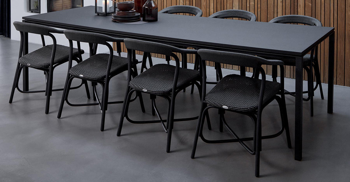 Noble Indoor Armchair by Cane-Line, showing noble indoor armchairs with table in live shot.