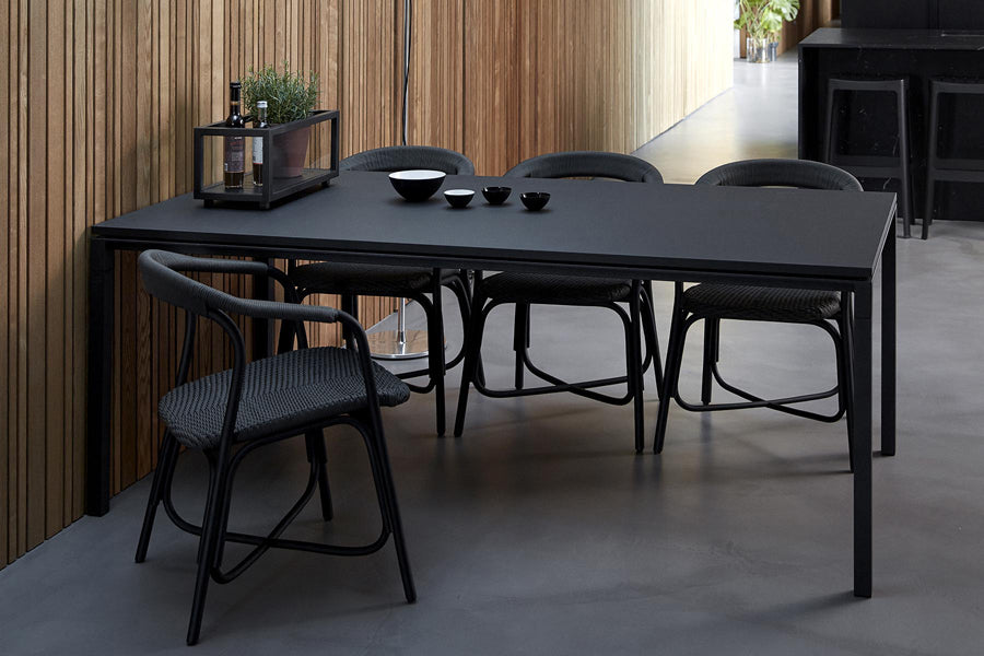 Noble Indoor Armchair by Cane-Line, showing noble indoor armchairs with table in live shot.