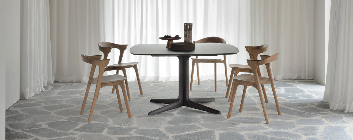 Corto Dining Table by Ethnicraft, showing corto dining table with chairs in live shot.