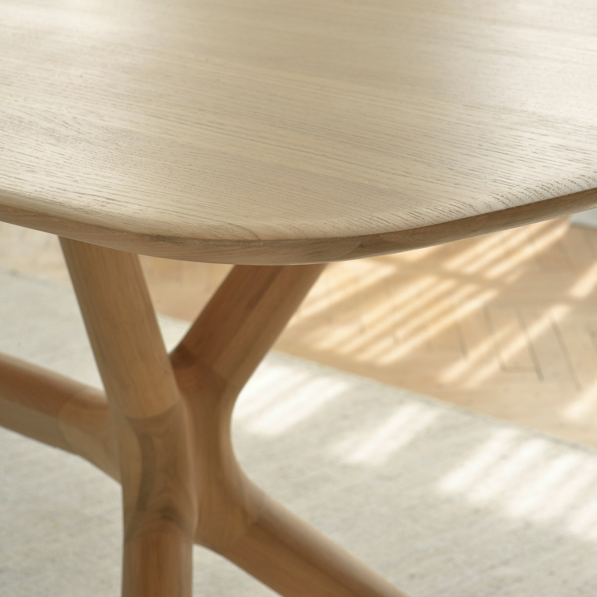 X Dining Table by Ethnicraft, showing closeup view of oak x dining table in live shot.