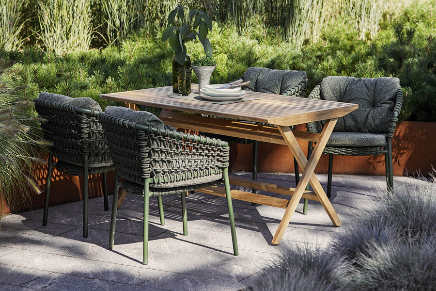 Ocean Stackable Dining Chair by Cane-Line, showing ocean stackable dining chairs with table in live shot.