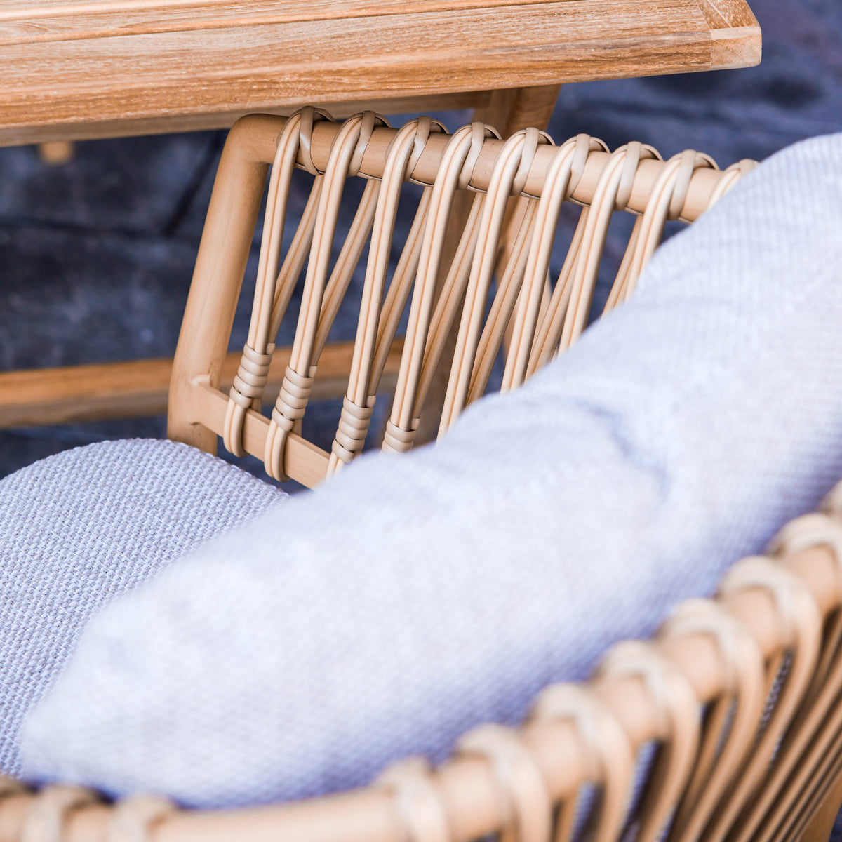 Ocean Stackable Natural/Aluminum Dining Chair by Cane-Line, showing closeup view of ocean stackable natural/aluminum dining chair in live shot.