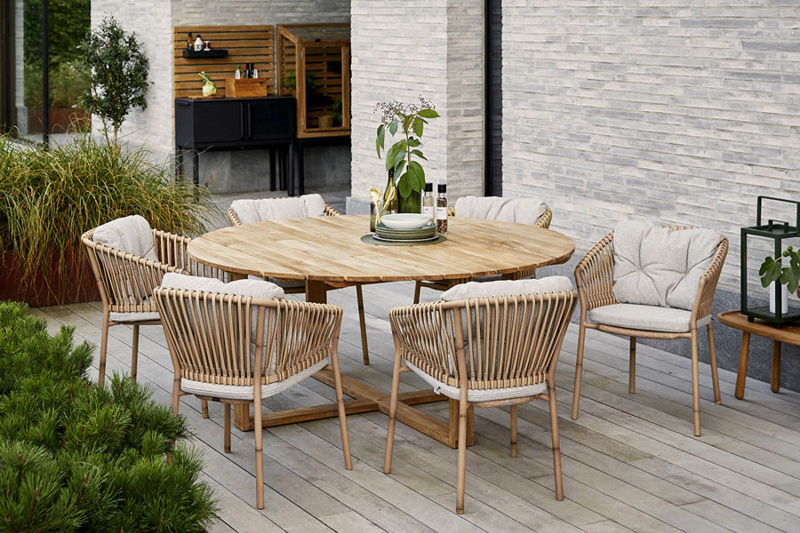 Ocean Stackable Natural/Aluminum Dining Chair by Cane-Line, showing ocean stackable natural/aluminum dining chairs in live shot.