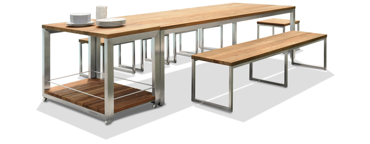 Oko Dining Bench by Mamagreen, showing angle view of oko dining bench with dining table, stools & trolley in hairline 304 stainless steel/brushed recycled teak wood.
