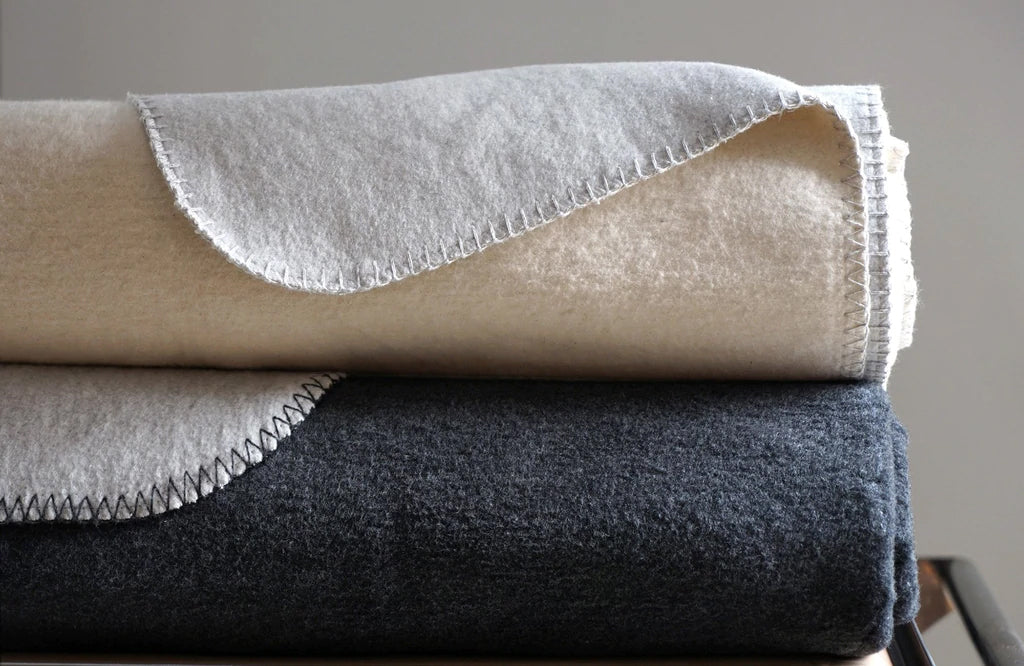 Oliver Blanket by Area, showin charcoal/ash & ash/cream blankets in live shot.
