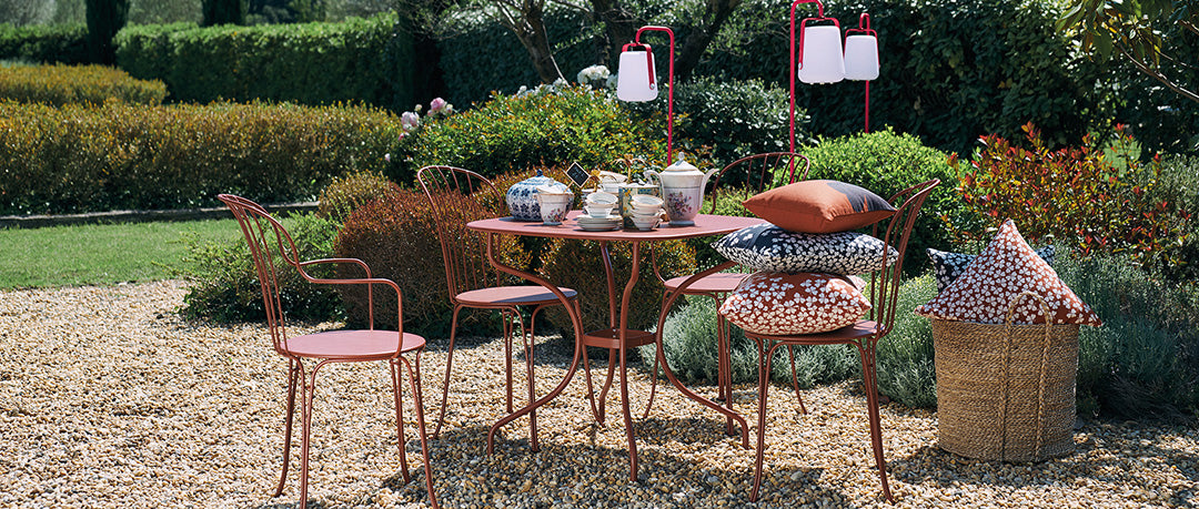 Opera+ Carronde Table by Fermob, showing opera+ liquorice carronde table with chairs in live shot.