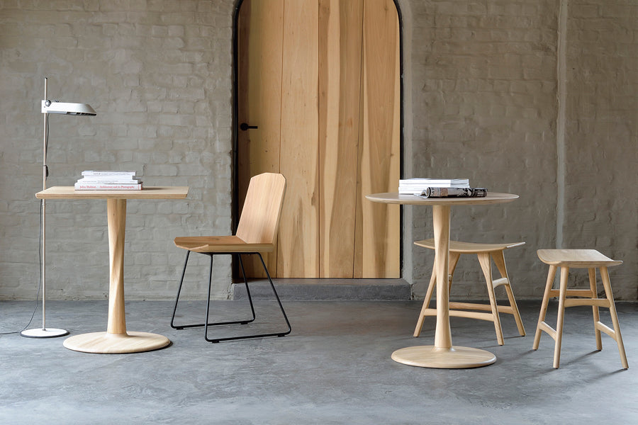 Osso Dining Stool by Ethnicraft, showing osso dining stools with tables & chair in live shot.