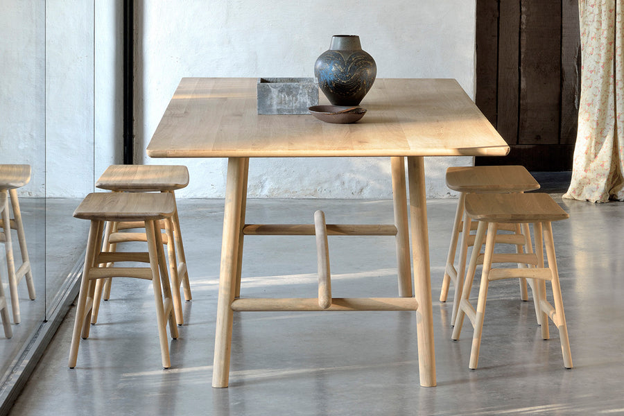 Osso Dining Stool by Ethnicraft, showing osso dining stools with table in live shot.