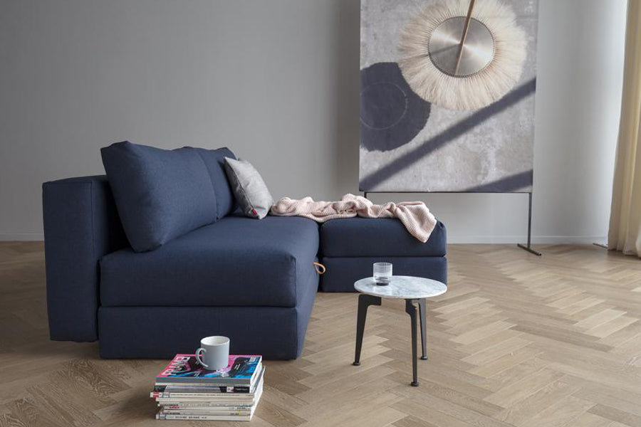 Osvald Sofa Bed by Innovation, showing osvald sofa bed with ottoman & table in live shot.