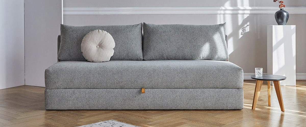 Osvald Sofa Bed by Innovation, showing osvald sofa bed with table in live shot.