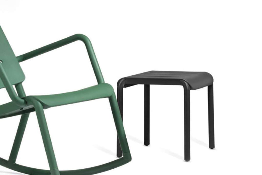 Outo Hocker Side Table by Toou, showing angle view of outo hocker side table in black with chair.