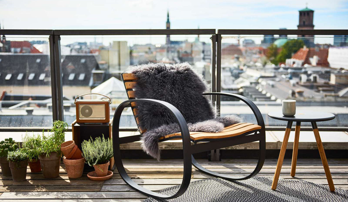 Parc Rocking Chair by Cane-Line, showing parc rocking chair with table in live shot.