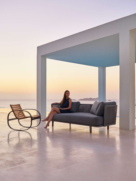Parc Rocking Chair by Cane-Line, showing parc rocking chair with sofa in live shot.