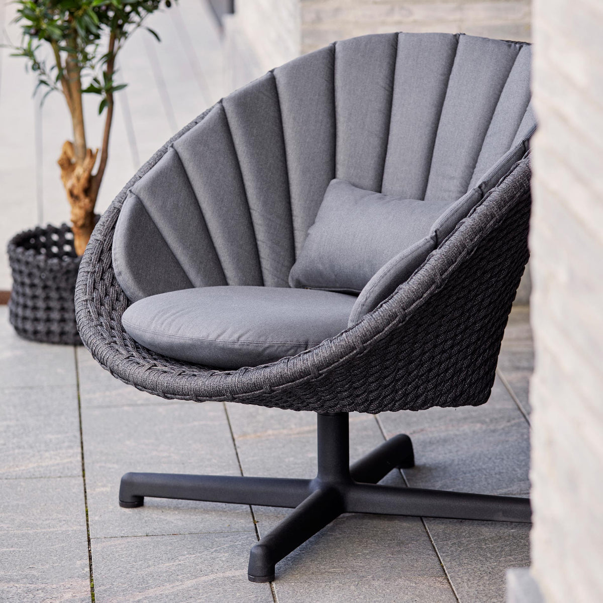 Peacock Outdoor Swivel Lounge Chair by Cane-Line, showing peacock outdoor swivel lounge chair in live shot.