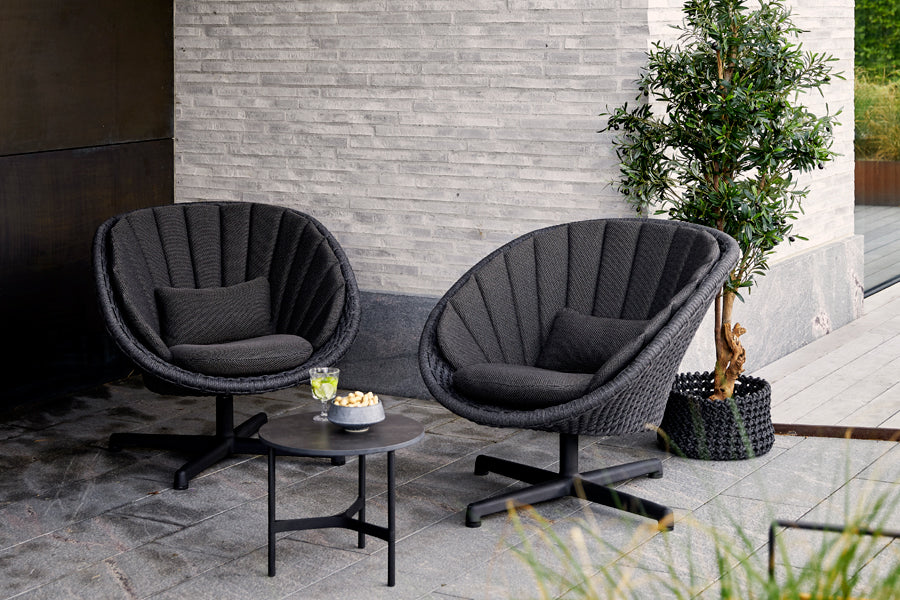 Peacock Outdoor Swivel Lounge Chair by Cane-Line, showing peacock outdoor swivel lounge chairs in live shot.